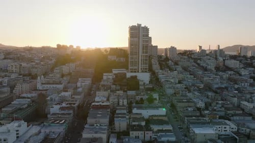 Fly Above Buildings in Metropolis Residential Urban Borough Against Setting Sun