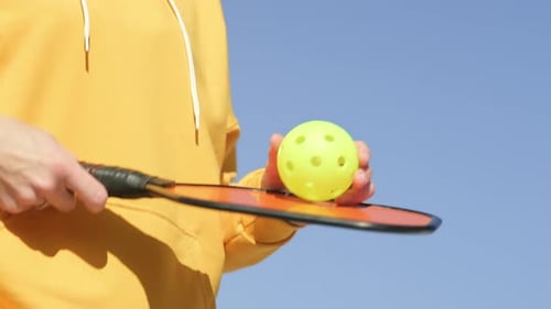 Pickleball Paddle and Yellow Ball Close Up Woman Playing Pickleball Game Hitting Pickleball Yellow