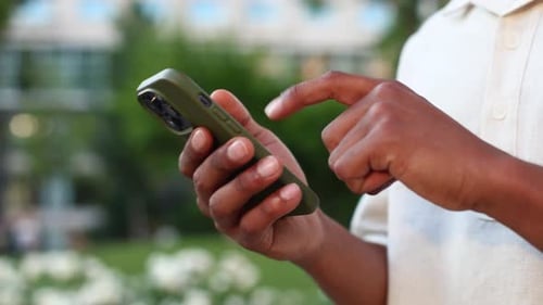 Person Using Smartphone Outdoors in Urban Park