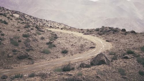 Sentier rocheux sinueux à travers les hauts plateaux de l'Ouzbékistan avec une végétation clairsemée