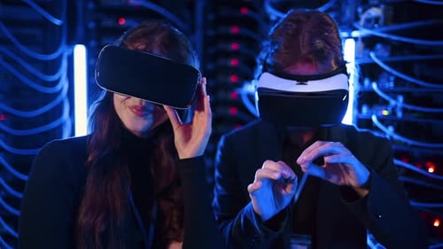 A man and a woman using Virtual Reality headsets in a server room