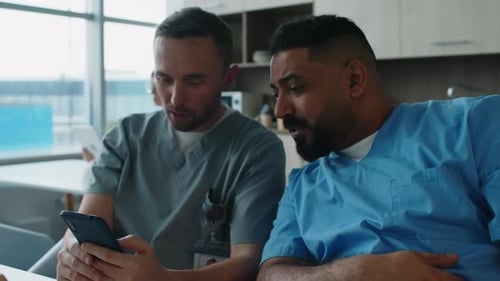 Hospital Workers Using Phone and Having Talk in Break Room
