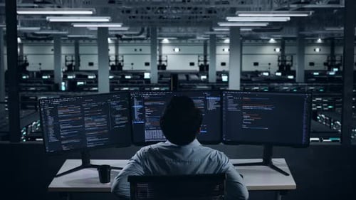 Rückansicht eines Entwicklers aus Asien, der beim Schreiben von Code im Rechenzentrum Rückenschmerzen hat