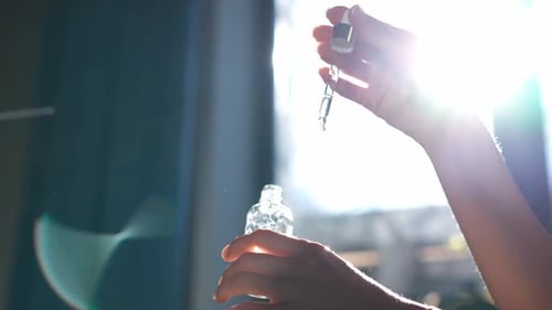 Woman Applies Serum in Sunny Room