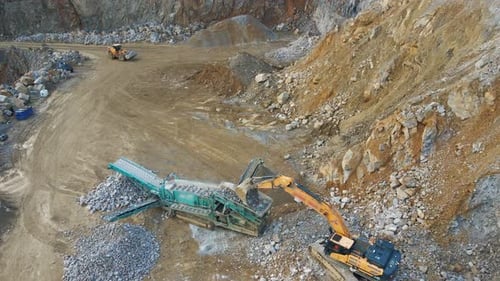 Efficient Material Handling: An Excavator, Tracked Incline Screener, and Wheel Loader at Work in a M