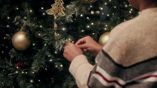 Decorating Christmas Tree with Ornaments at Home