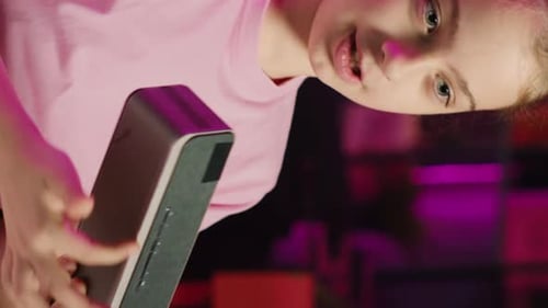 Girl Demonstrates Bluetooth Speaker with Neon Lighting