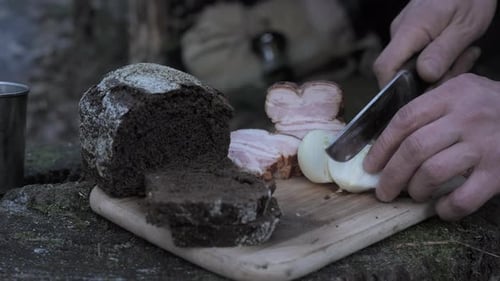 Rustic Outdoor Meal Preparation with Black Bread and Smoked Pork