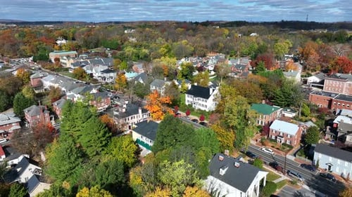 Historical houses lining town street with autumn trees. Aerial view of New England in fall.