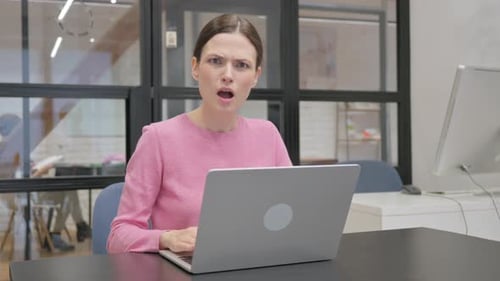 Woman Reacts to Computer in Modern Office
