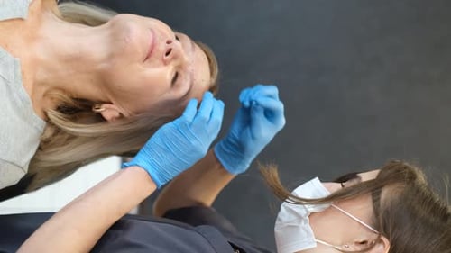Vertical Video of a Cosmetologist Making Injections in a Cosmetic Clinic A Doctor Injects Vertical