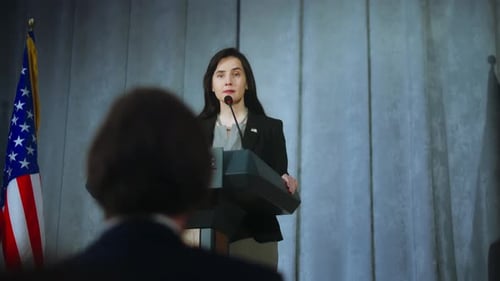 Woman Giving a Press Conference at Podium