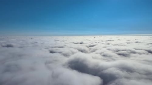 Aerial View From Airplane Window at High Altitude of Earth Covered with Puffy Cumulus Clouds Forming