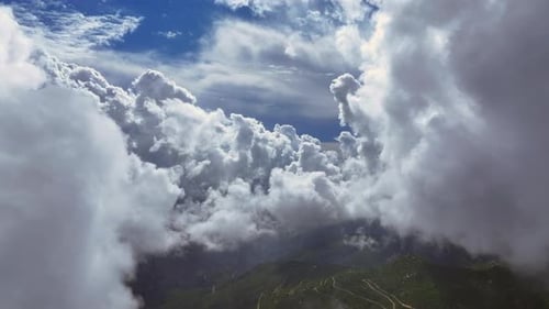 Dramatic cloud formations above a mountain landscape during midday
