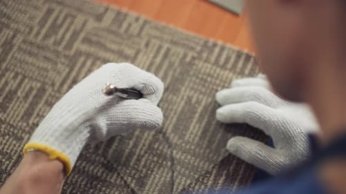 Hand with Tool Adjusting Carpet Close Up