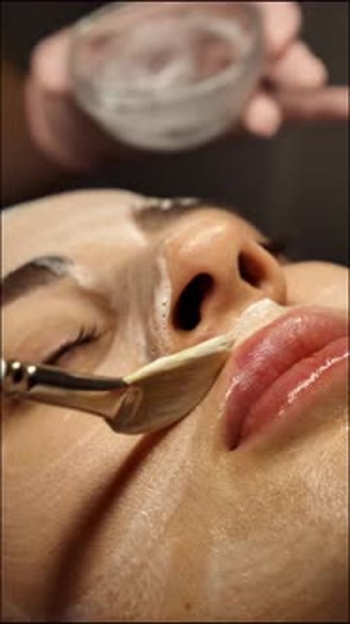 Woman Receiving Facial Mask Applied with Brush