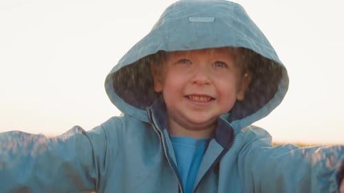 Boy Stands Delighting in Warmth of Rain