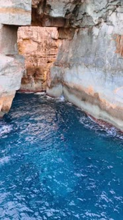 Rocky coast of Malta, Europe. Approaching high cliffs at the shore of the Mediterranean Sea.