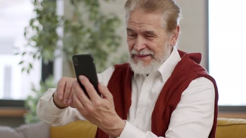 Senior Man Using a Smartphone at Home