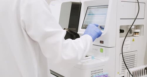 Lab Technician Operating Medical Analysis Machine
