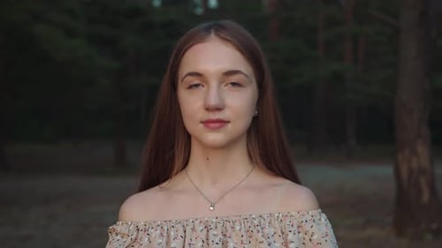 Portrait of a Beautiful Sensual Young Girl in a Romantic Dress on the Background of a Pine Forest