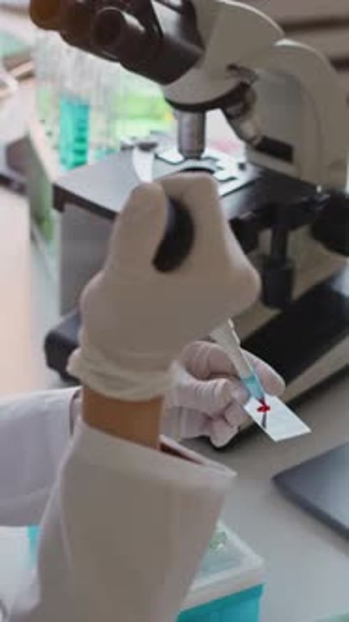 Lab Worker Prepares Blood Sample for Microscope Analysis