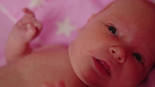 Adorable Baby Lying on a Pink Blanket