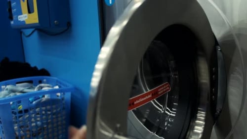 close-up of a woman in the laundry room putting things into the washing machine