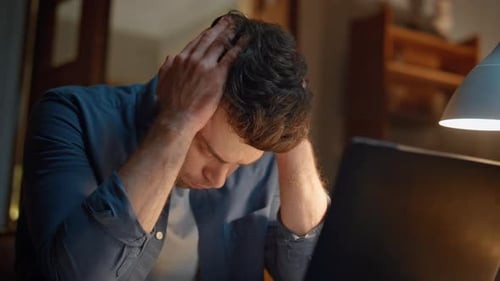 Man Looks Shocked While Using Computer At Night