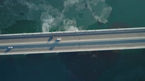 Aerial Top Down View of Lowwater Bridge Across the Bay with Moving Car Active Movement of Transport