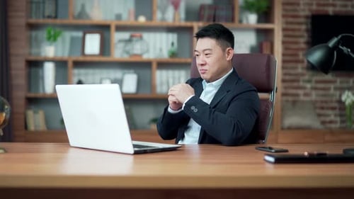 Cheerful Businessman Celebrating Success on Laptop Video Call