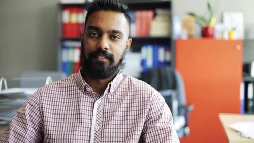 Concepto de negocios, emociones, expresión y personas: hombre feliz y sonriente con barba en la oficina