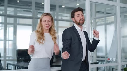Deux collègues de travail dansent au bureau Un homme d'affaires caucasien d'âge moyen avec une femme d'affaires danse