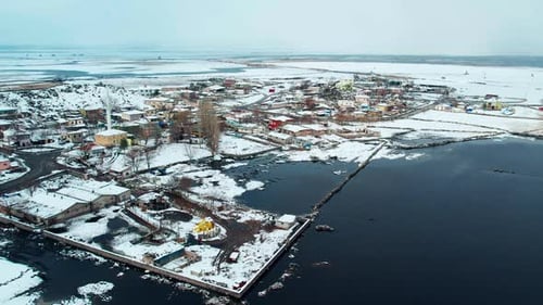 Aerial View of Snowy Lakeside Village in Winter