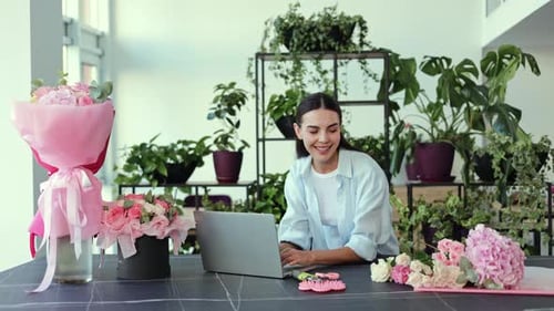 Florist Working in Flower Shop with Laptop