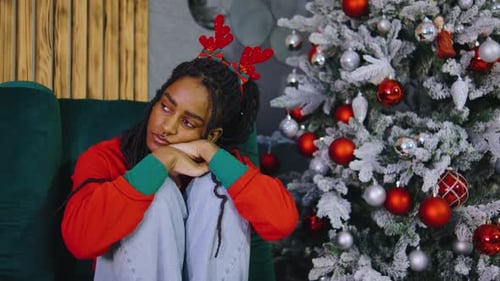 A Young Woman Feels Lonely and Upset in a Christmasdecorated Room Surrounded By Festive Decor She