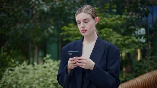 Woman Uses Smartphone Outdoors in Urban Setting