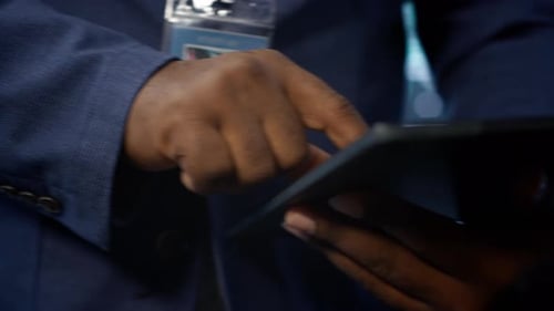 Close Up Shot of Man Using Tablet in Data Center Ensuring Rigs are Functioning
