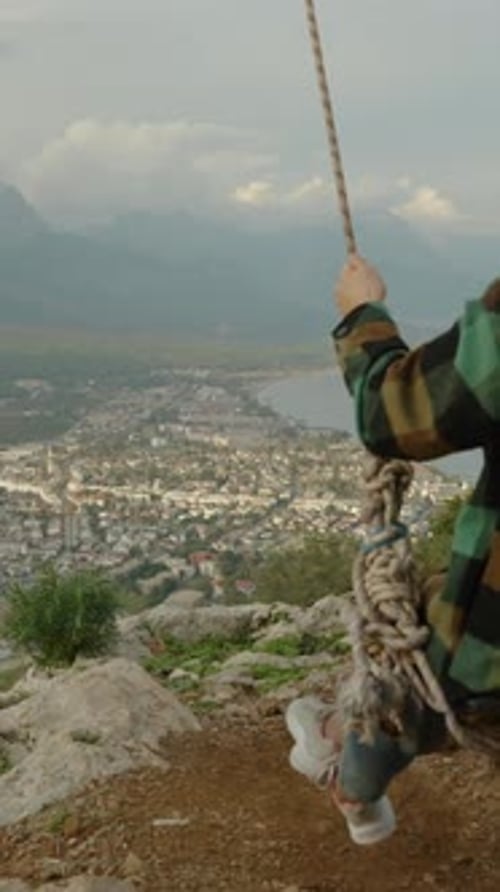 Woman Swings With Scenic City View