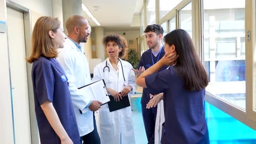 Medical Team Discussing Patient Status in Hospital Corridor