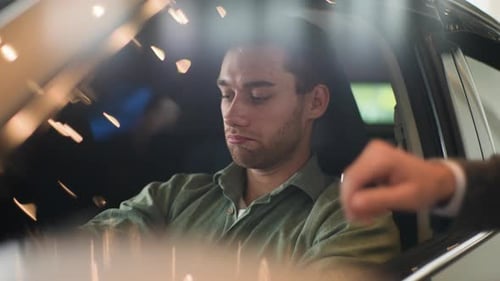 Young Adult Examines Car Interior at Showroom