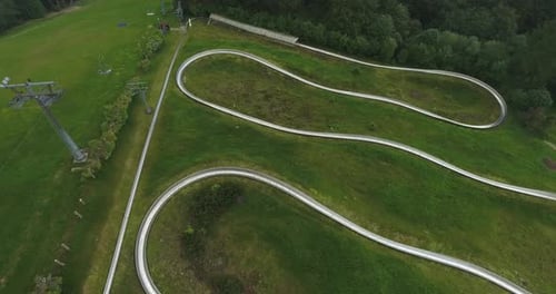 A summer toboggan track on top of a mountain in a tourist town in Poland. Captured from a drone, 4K