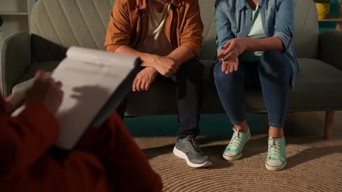 Couple on Couch Talking with Therapist Taking Notes