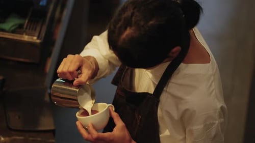 Barista Pouring Milk for Latte Art Creation