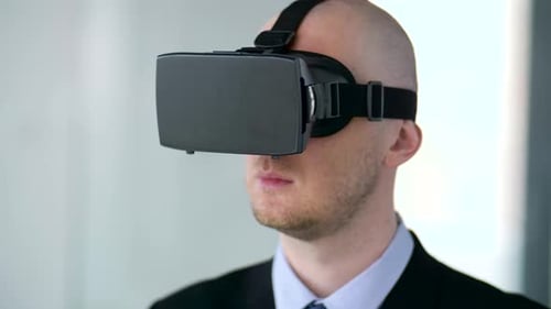 Businessman immersed in augmented reality at his modern office wearing vr headset
