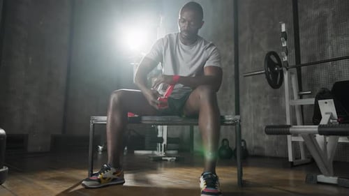 Boxer Wraps Type en la mano para entrenar a un luchador afroamericano que se prepara para el entrenamiento de competencia