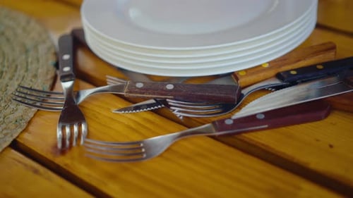 Platos apilados con cubiertos rústicos sobre madera