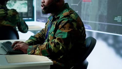 People Wearing Camouflage Using Computers in an Office
