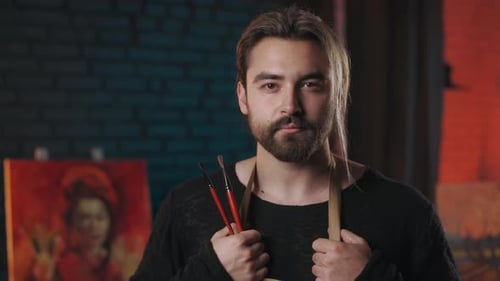 Male Art Master Standing in Studio and Holding Brushes
