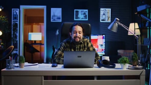 Man Working From Home On Laptop At Night